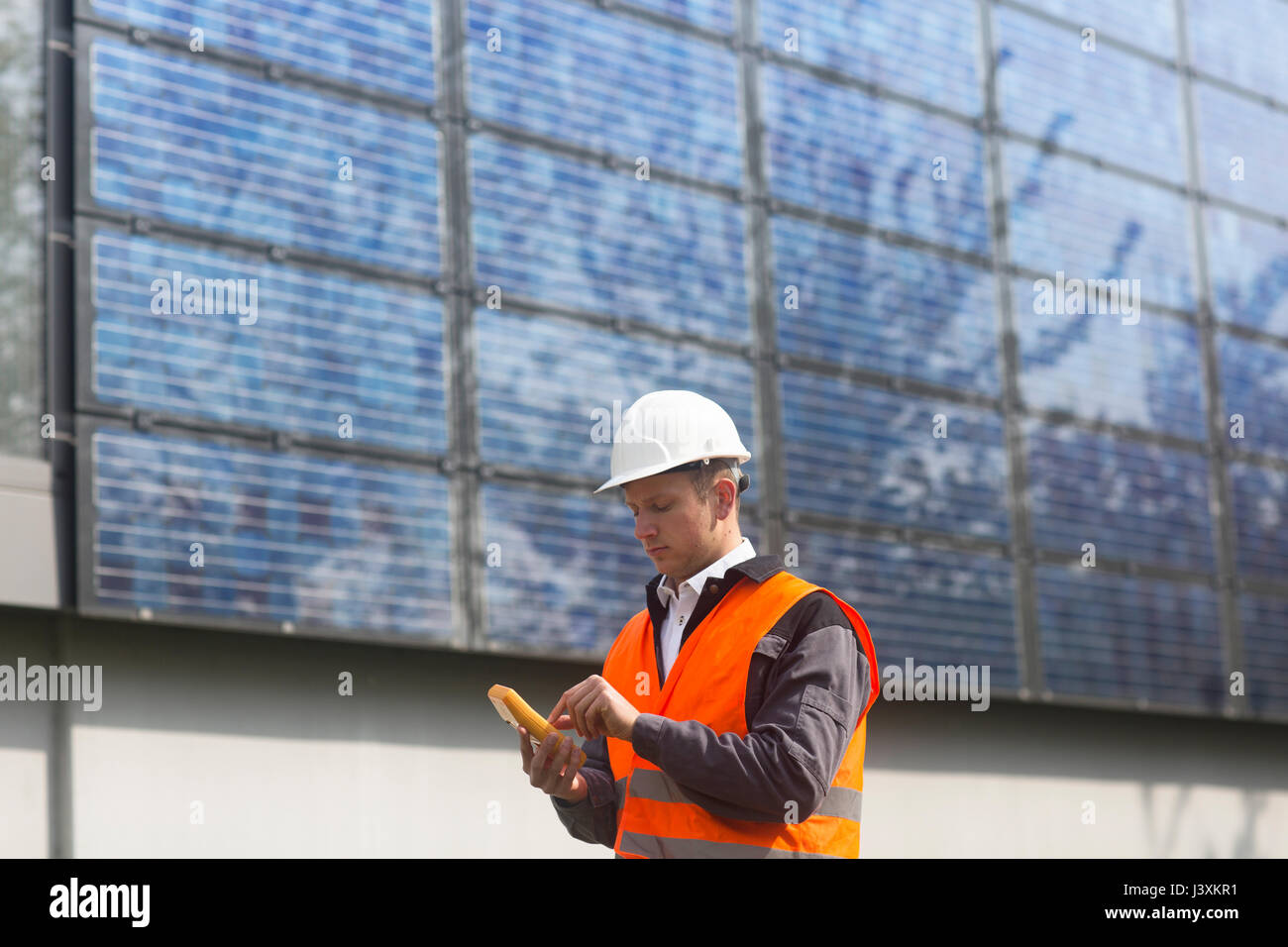 Männliche Ingenieur mit Multimeter auf solar panel Website Stockfoto