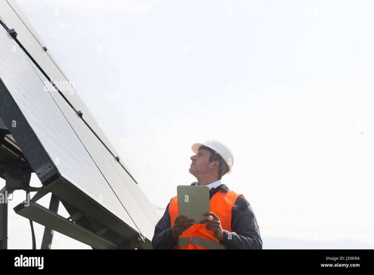 Junge männliche Techniker mit digitalen Tablet oben Sonnenkollektoren Stockfoto
