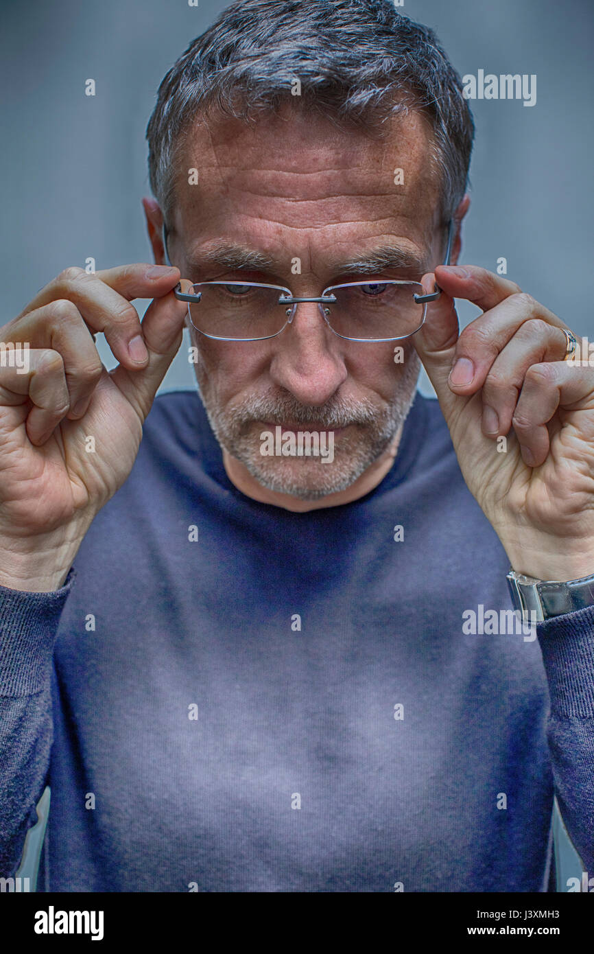 Porträt von Vergrauung reifen Mann Brille entfernen Stockfoto