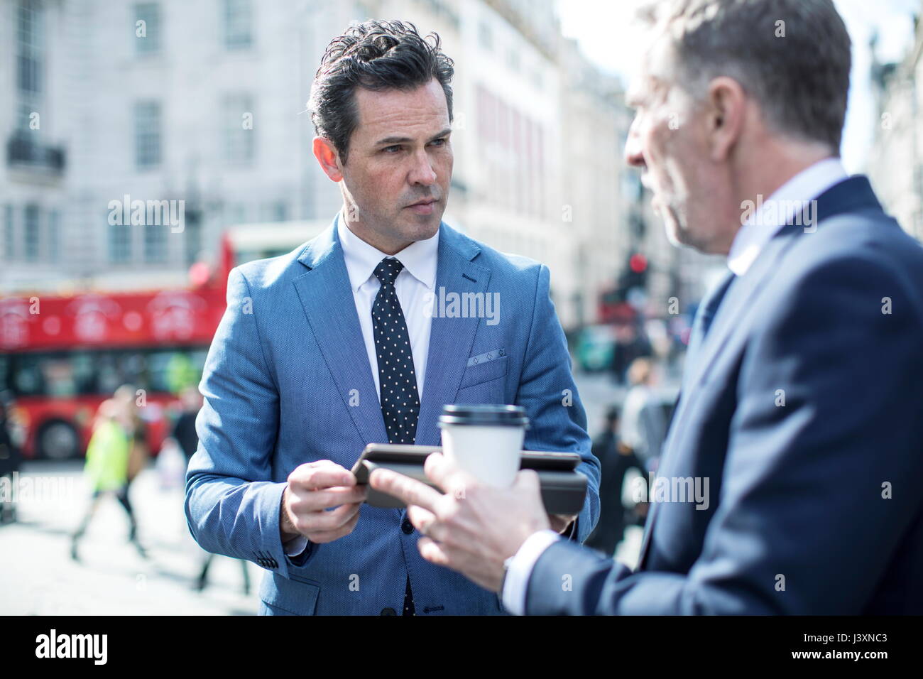 Die Unternehmer in der Straße mit digitalen Tablet, London, UK Stockfoto