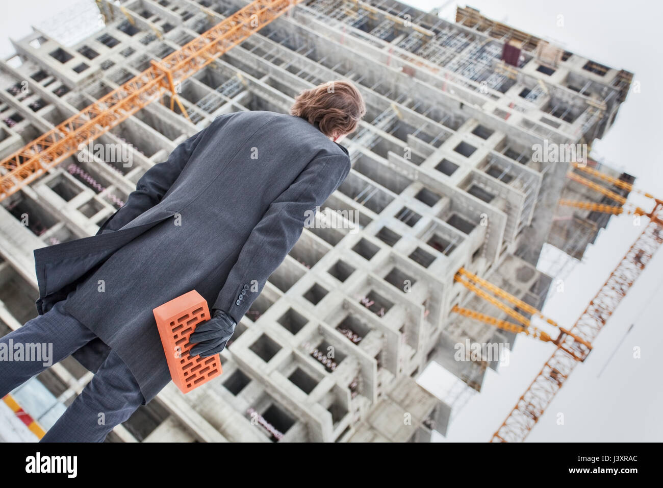 Mann bringt Ziegel auf der Baustelle, einen persönlichen Beitrag leisten.  Private Investitionen, Beitrag zum Baukonzept. Moskau. R Stockfoto