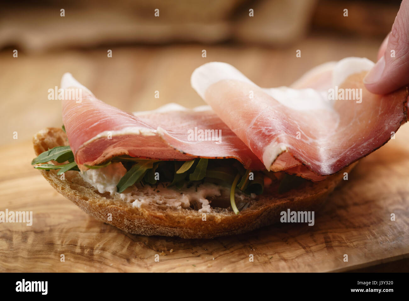 Italienisch-Sandwich mit Speck und Rucola Salat Stockfoto