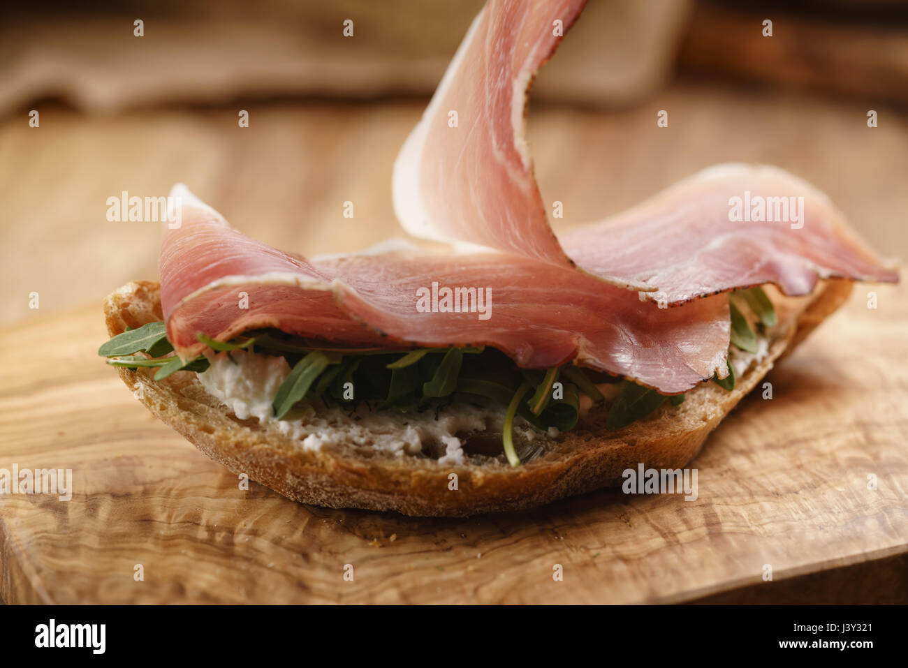 Italienisch-Sandwich mit Speck und Rucola Salat Stockfoto