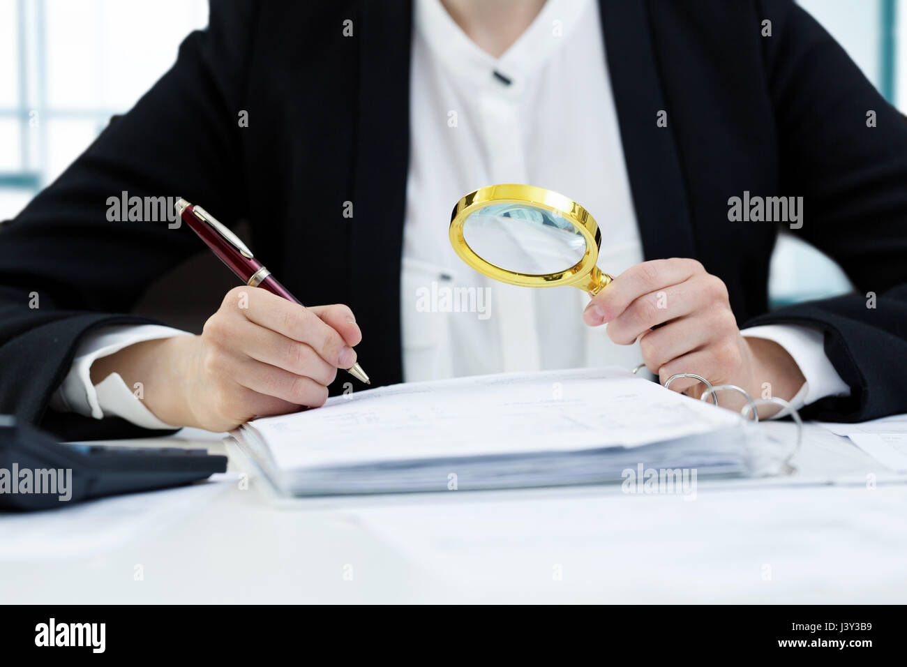 interne Audit-Konzept - Frau mit Lupe inspizieren Dokumente Stockfoto