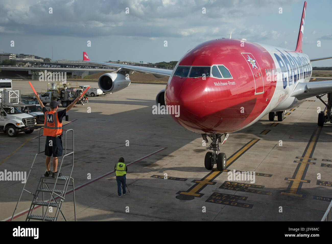 Flugzeug-Marschall mit Signalisierung-Sticks, um einen großen Passagier-Jet, eine exakte Position auf dem Vorfeld des Flughafen Tampa USA zu führen. Mai 2017 Stockfoto