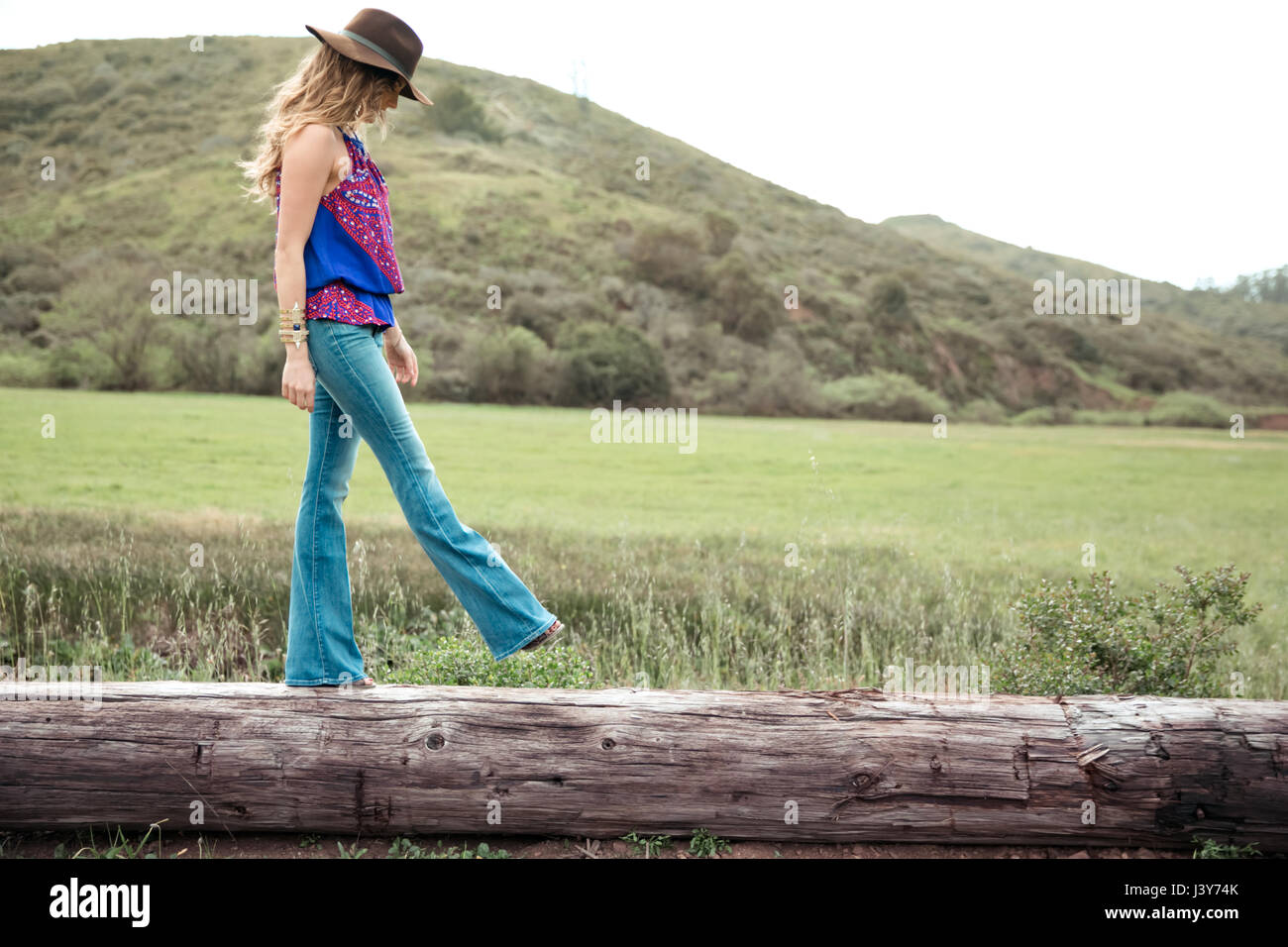 Boho Stil junge Frau zu Fuß entlang log Stockfoto