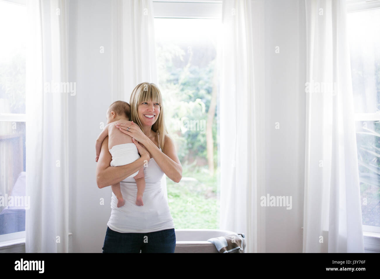 Mitte Erwachsene Frau mit Baby Sohn im Wohnzimmer Stockfoto