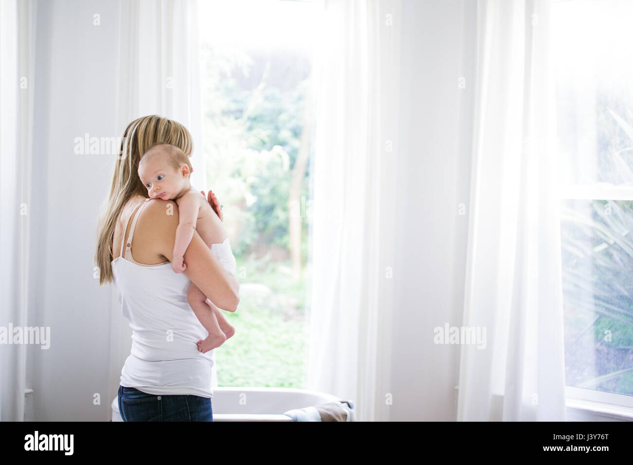 Mitte Erwachsene Frau mit Baby Sohn im Wohnzimmer Stockfoto