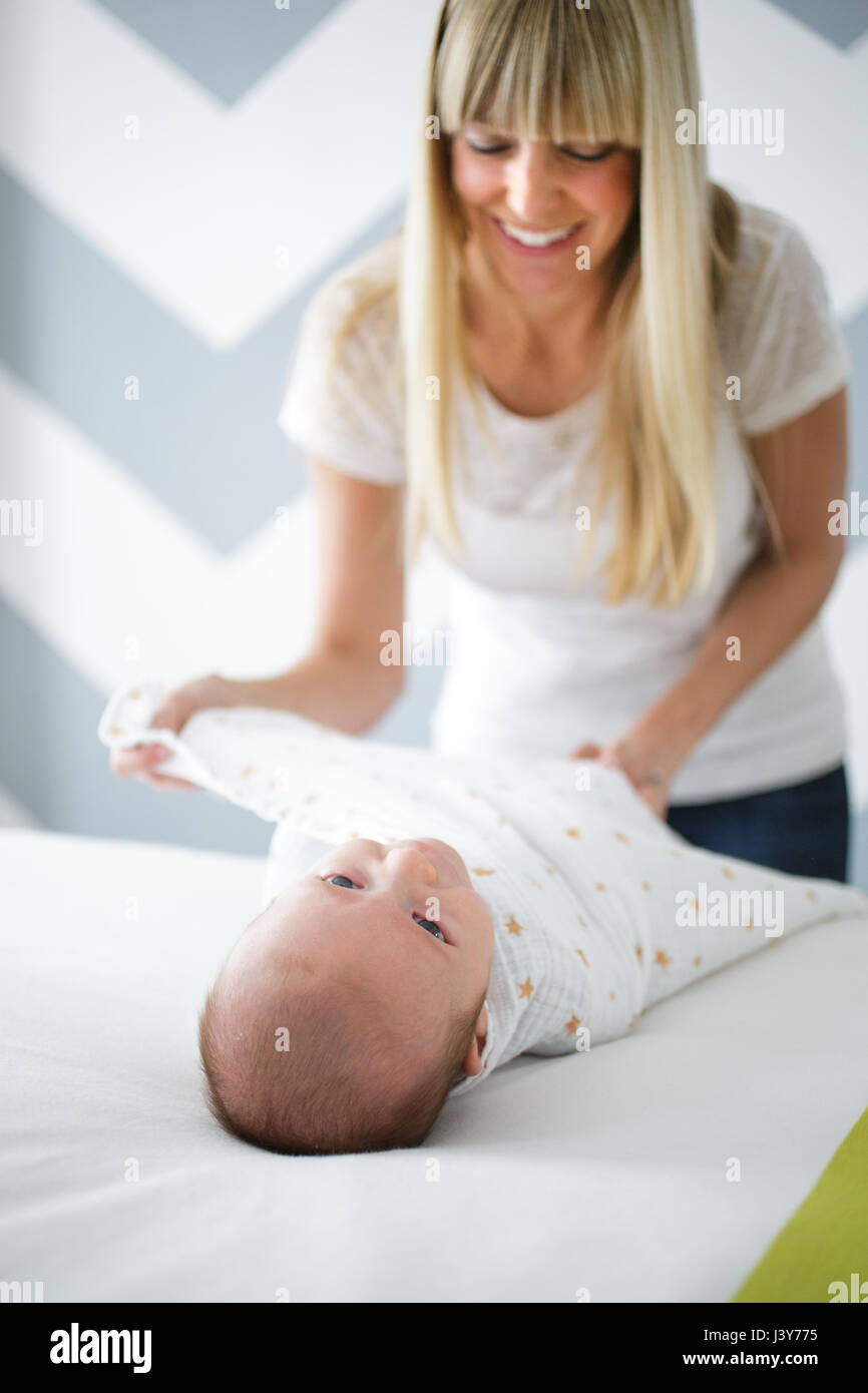 Mitte adult Windeln Baby Sohn Frau auf Bett Stockfoto