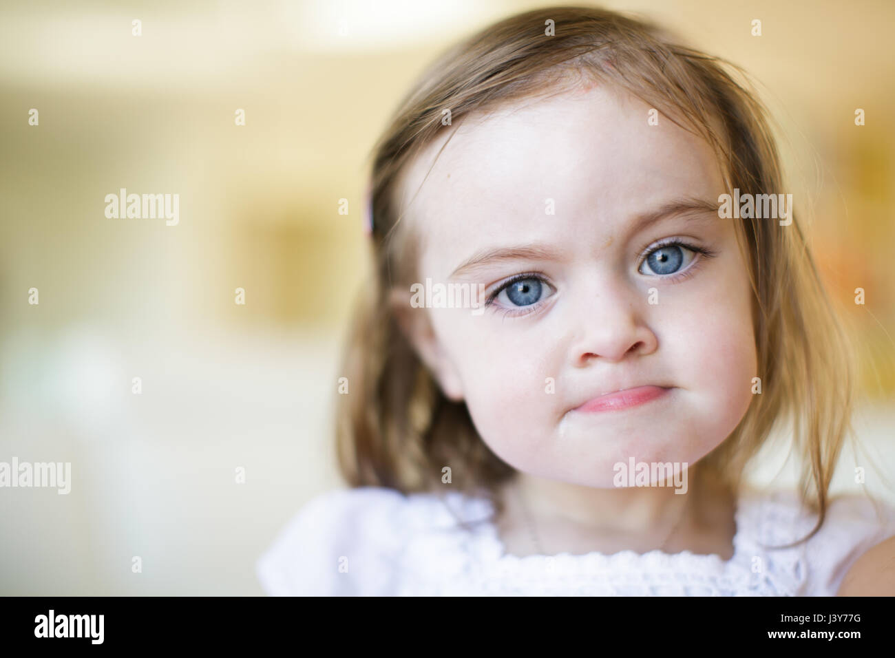 Porträt von Blue eyed weiblichen Kleinkind Lippe beißen Stockfoto