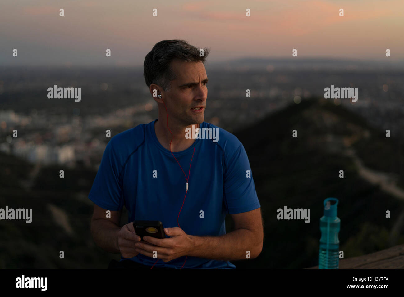Jogger tragen Kopfhörer halten Smartphone, Runyon Canyon, Los Angeles, Kalifornien, USA Stockfoto