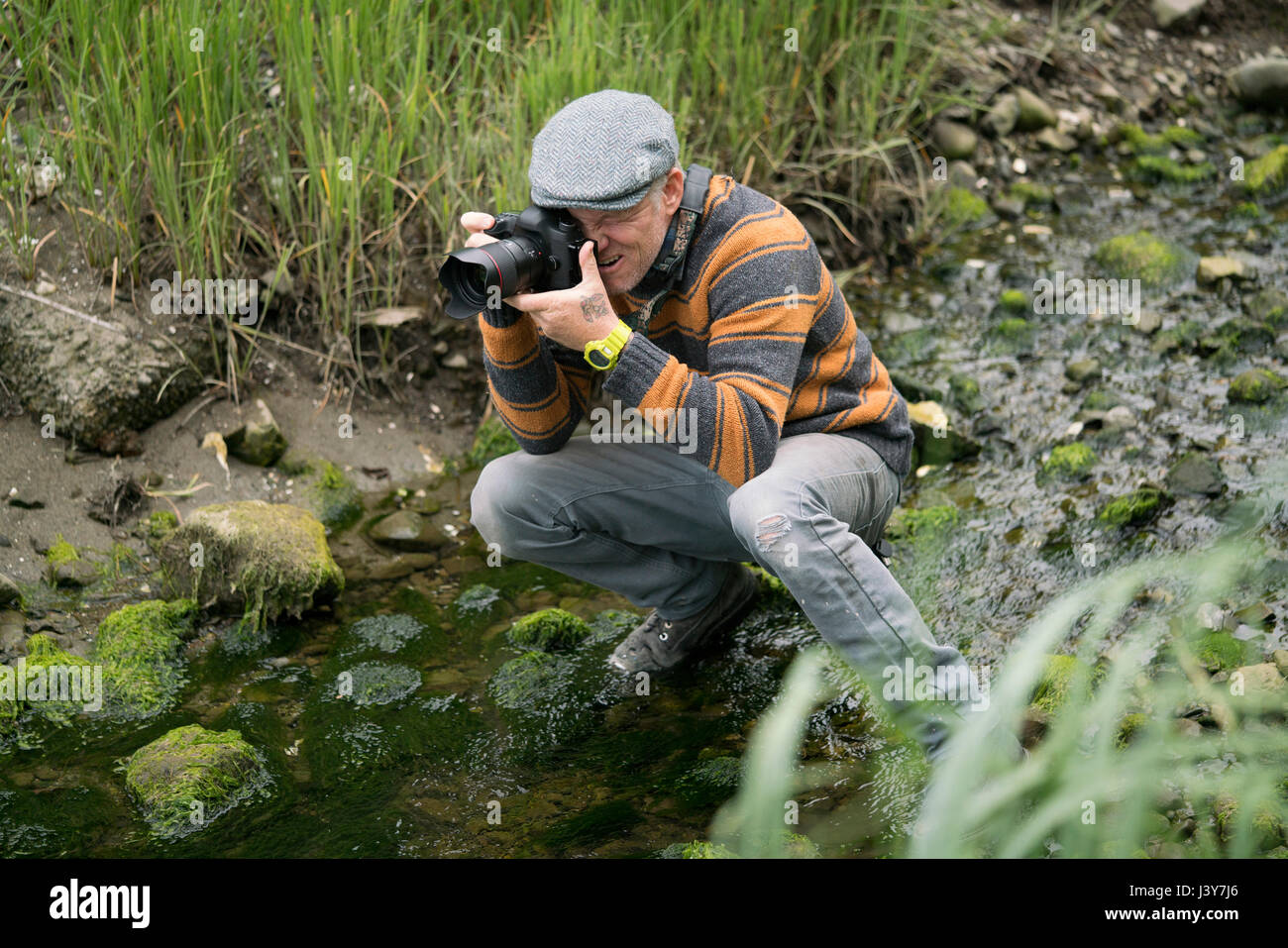 Mann hocken in seichten Fluss nehmen Foto Stockfoto