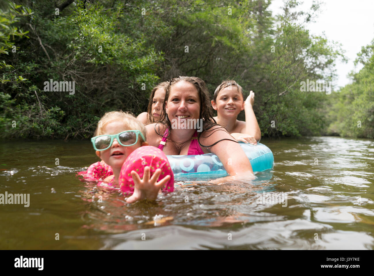 Mutter und Kinder mit aufblasbaren Ring in See, Niceville, Florida, USA Stockfoto