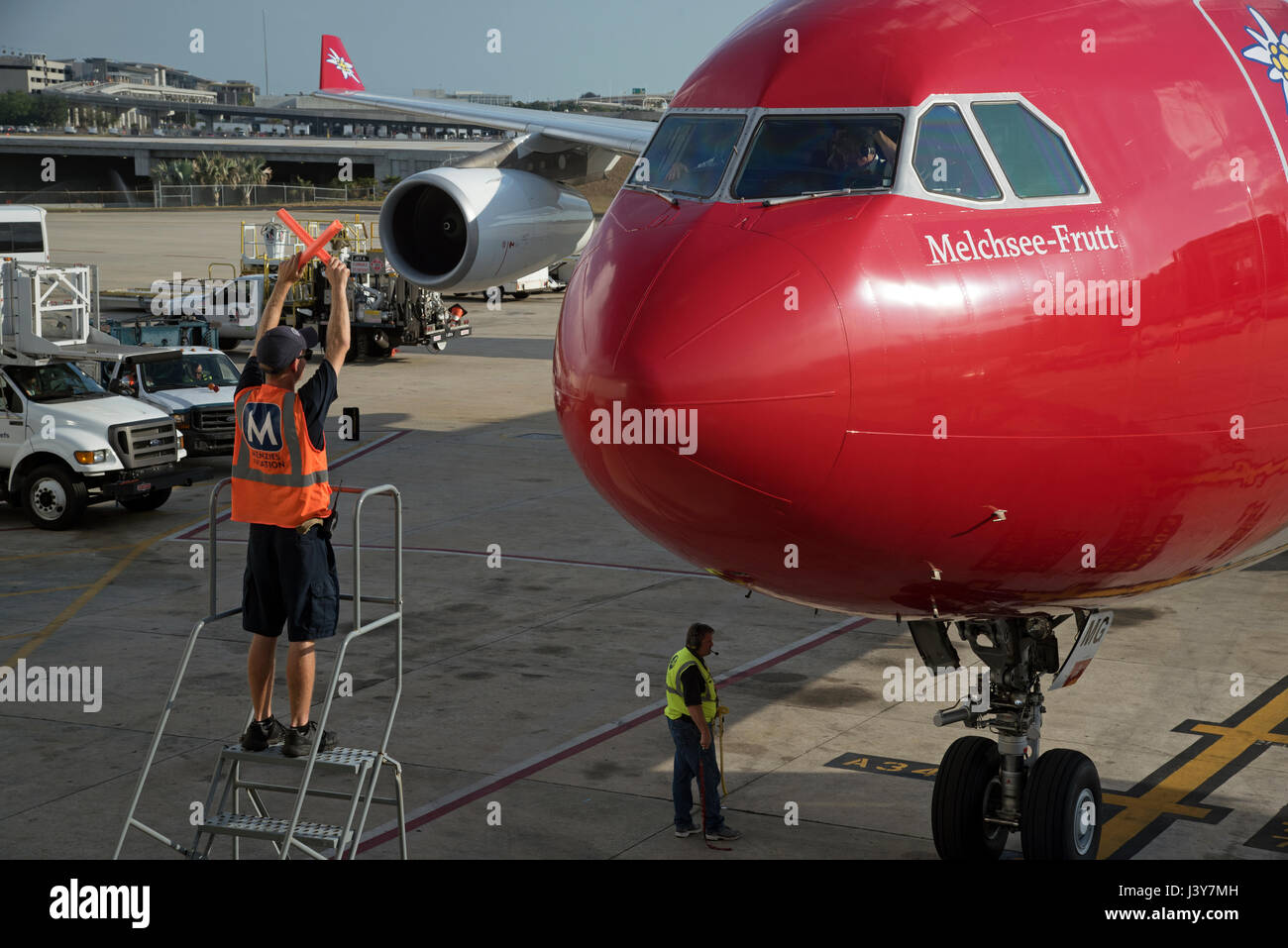 Flugzeug-Marschall mit Signalisierung-Sticks, um einen großen Passagier-Jet, eine exakte Position auf dem Vorfeld des Flughafen Tampa USA zu führen. Mai 2017 Stockfoto