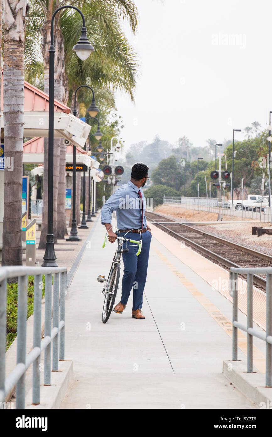 Junger Geschäftsmann Radfahrer aus Bahn-Bahnsteig im Rückblick Stockfoto