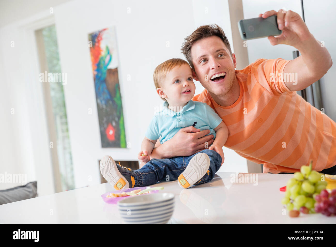 Vater und Kind Sohn nehmen Selfie in Küche zu Hause Stockfoto