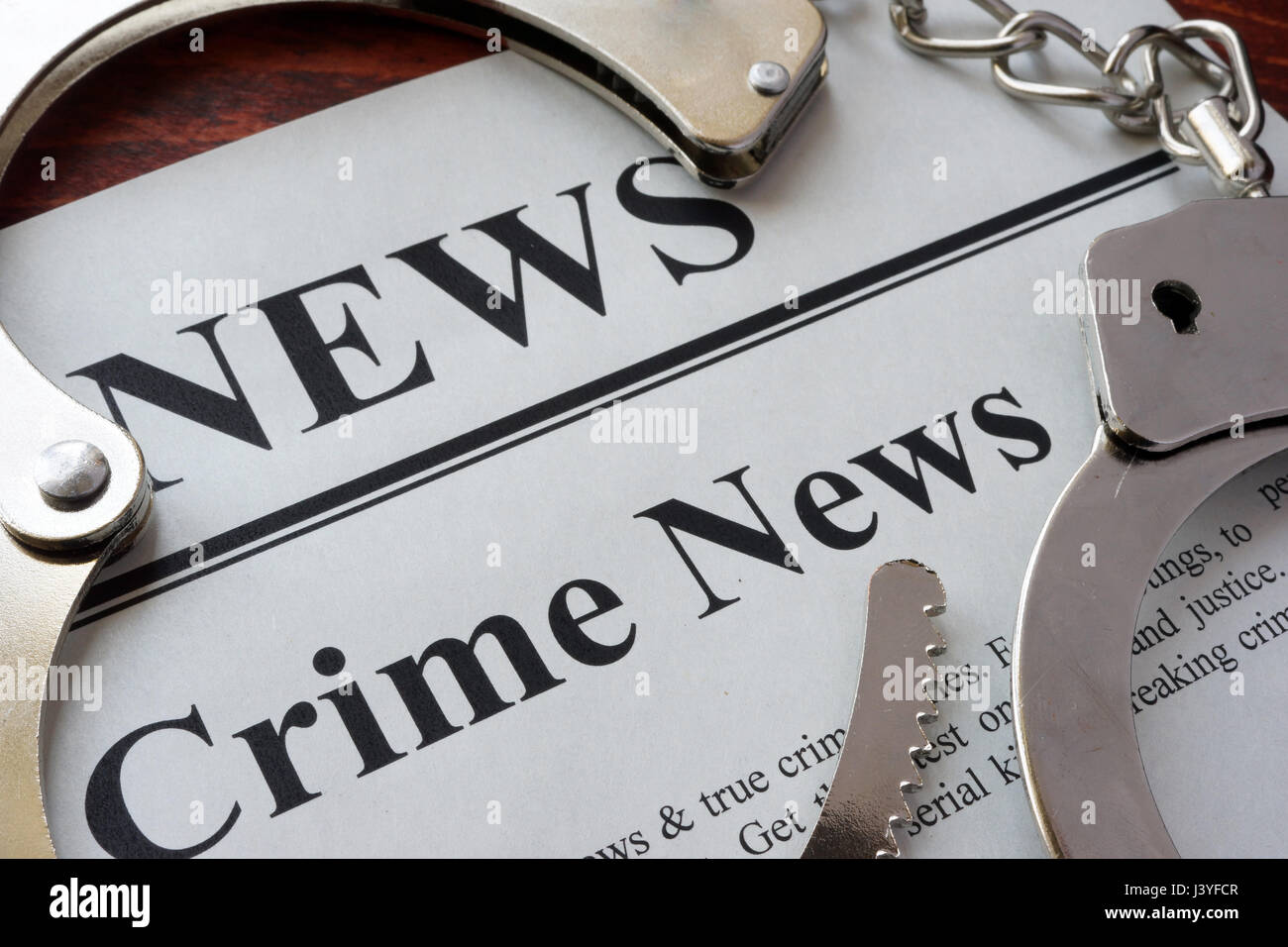 Zeitung mit Titel Crime News und Handschellen. Stockfoto