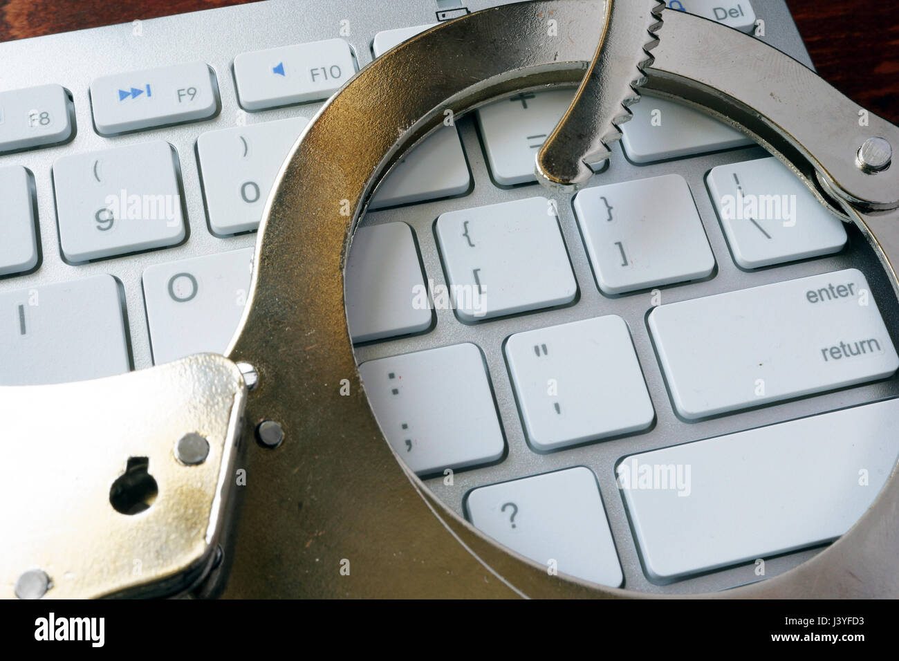 Online-Kriminalität-Konzept. Handschellen auf der Tastatur. Stockfoto