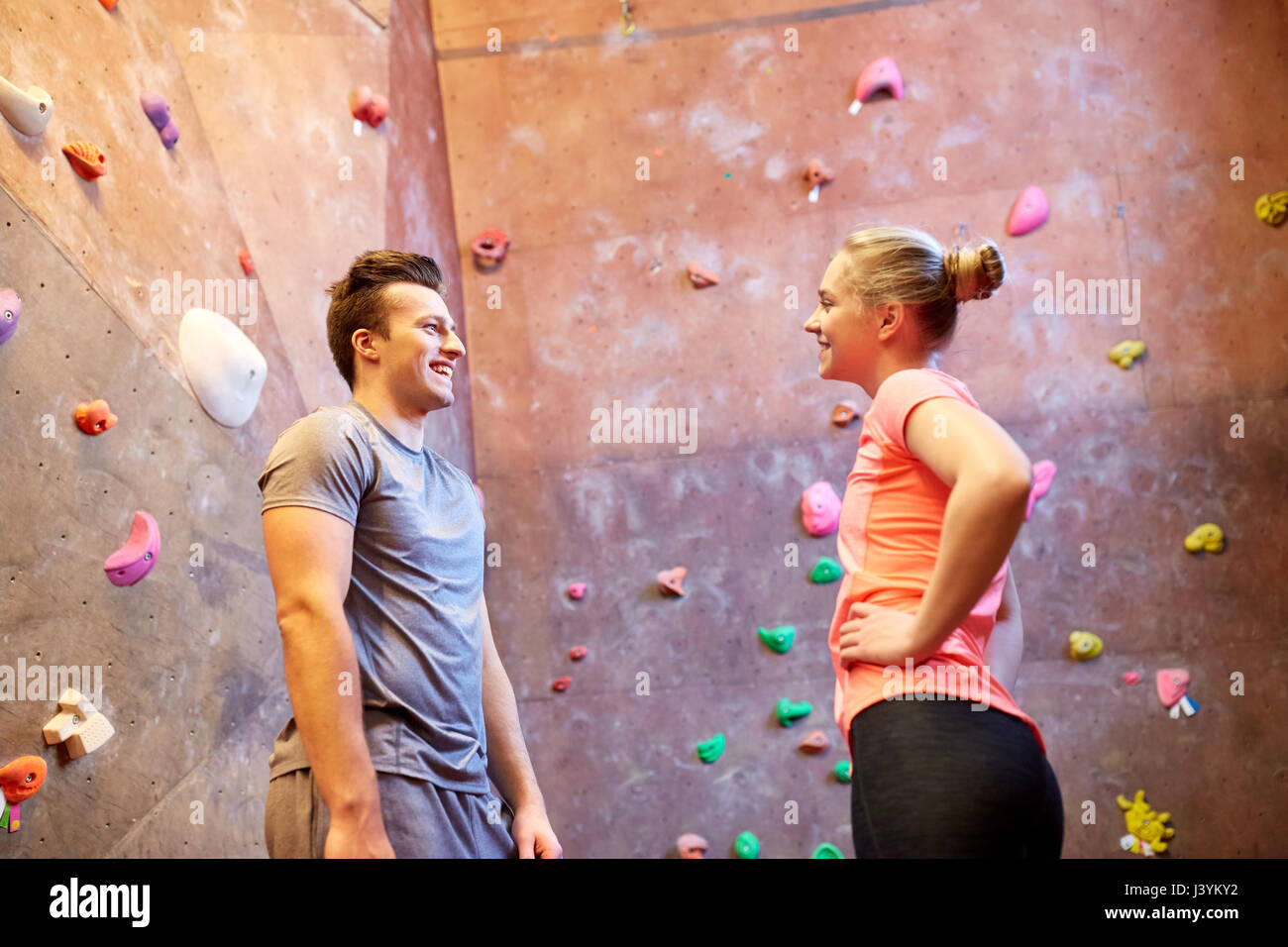 Mann und Frau sprechen an indoor Kletterwand Fitness-Studio Stockfoto