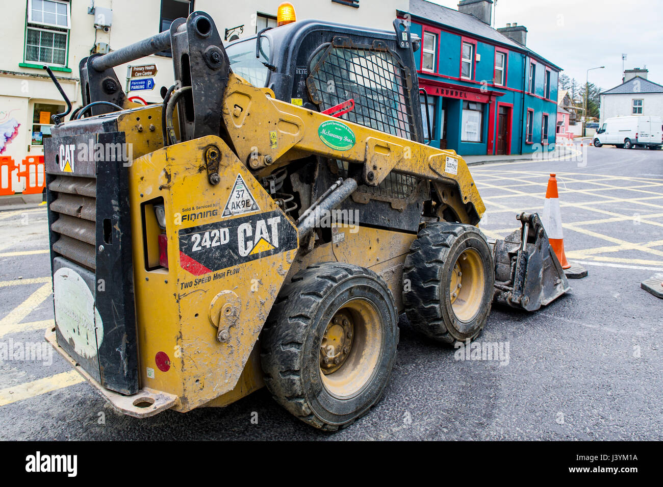 Caterpillar CAT 242D Kompaktlader in Schull Main Street, Schull, West Cork, Irland während Baustellen mit Textfreiraum. Stockfoto