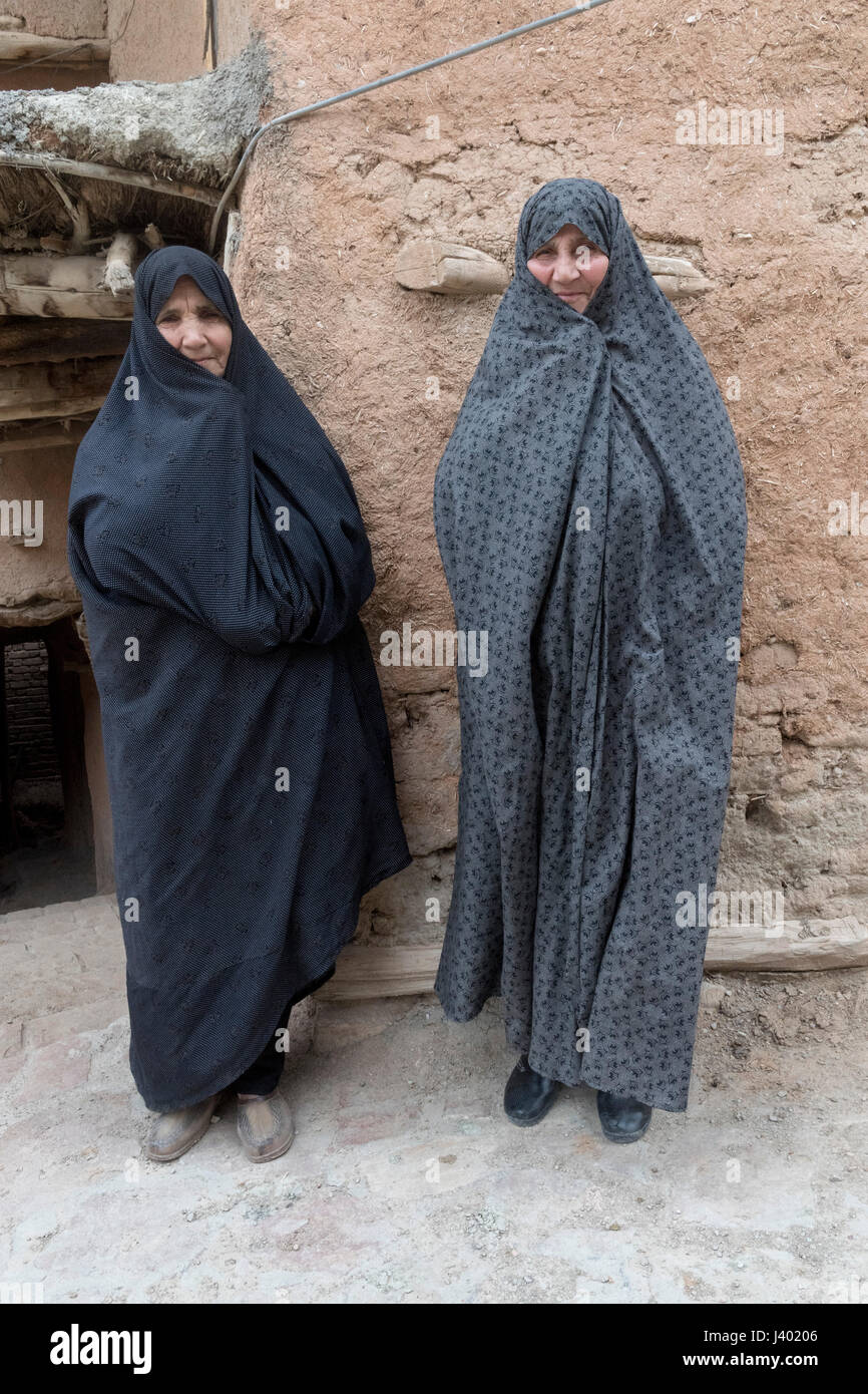 Zwei alte Damen tragen Tschador In der Straße, Rooieen (Ruine), ein traditionelles Dorf, Nord-Chorasan, IRAN - 04.01.2017. Das Hotel liegt ein paar ki Stockfoto