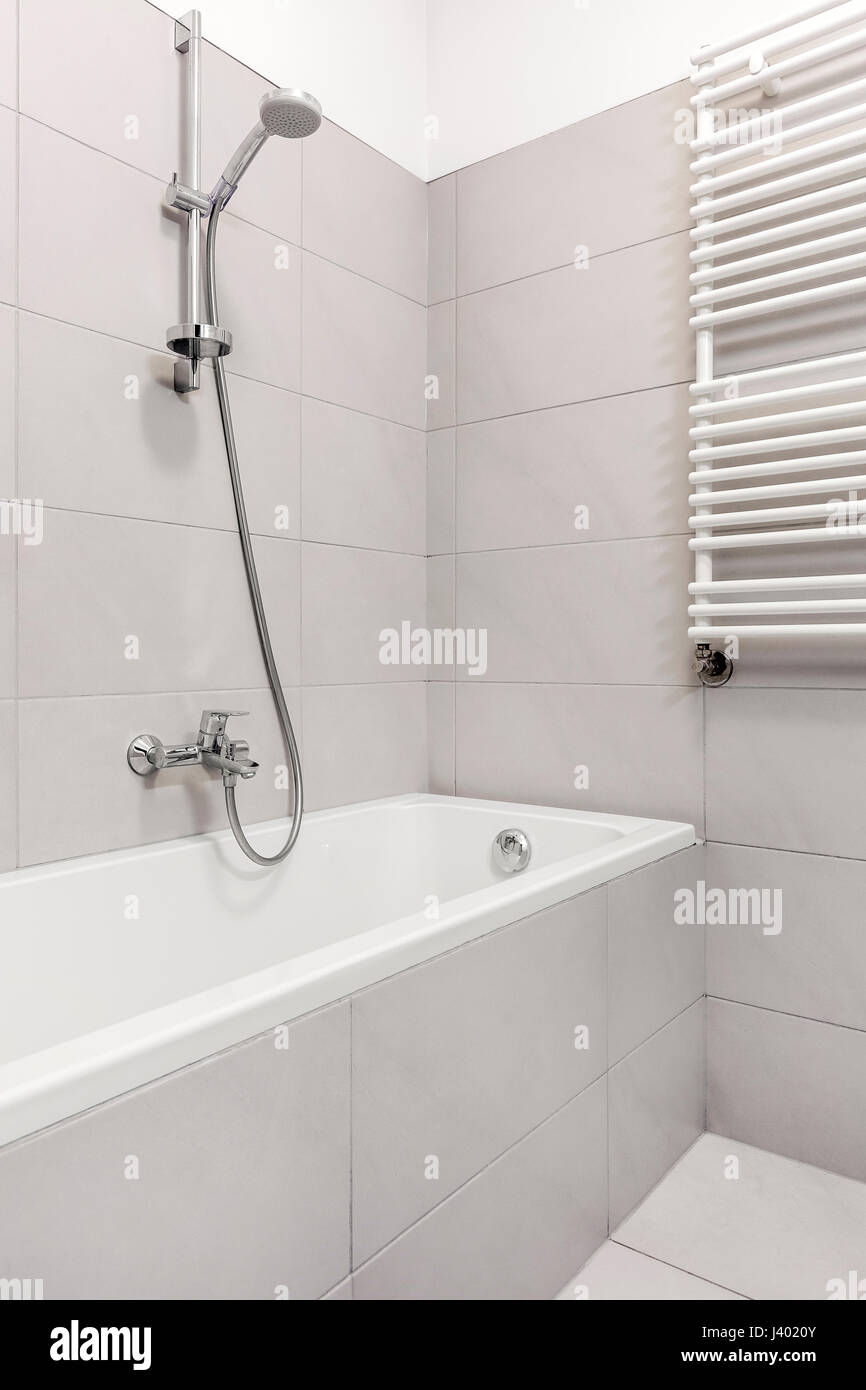 Einfache integrierte Badewanne mit grauen Fliesen im Haus Bad Stockfoto