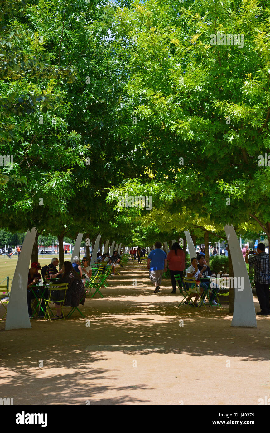 Öffentliche Sitzgelegenheiten unter Eichen und dekorative Bögen Linie, die die Promenade am Klyde Warren Park einer vertieften Autobahn in der Innenstadt von Dallas oberhalb Stockfoto