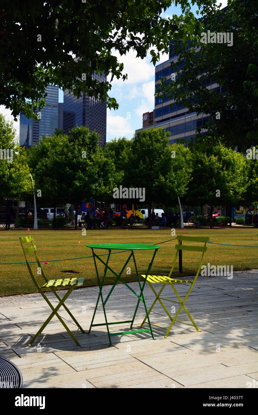 Öffentliche Tische und Stühle säumen die Wege und von Bäumen gesäumten Wege rund um Dallas' Downtown Klyde Warren Park auf einer vertieften Autobahn gebaut Stockfoto