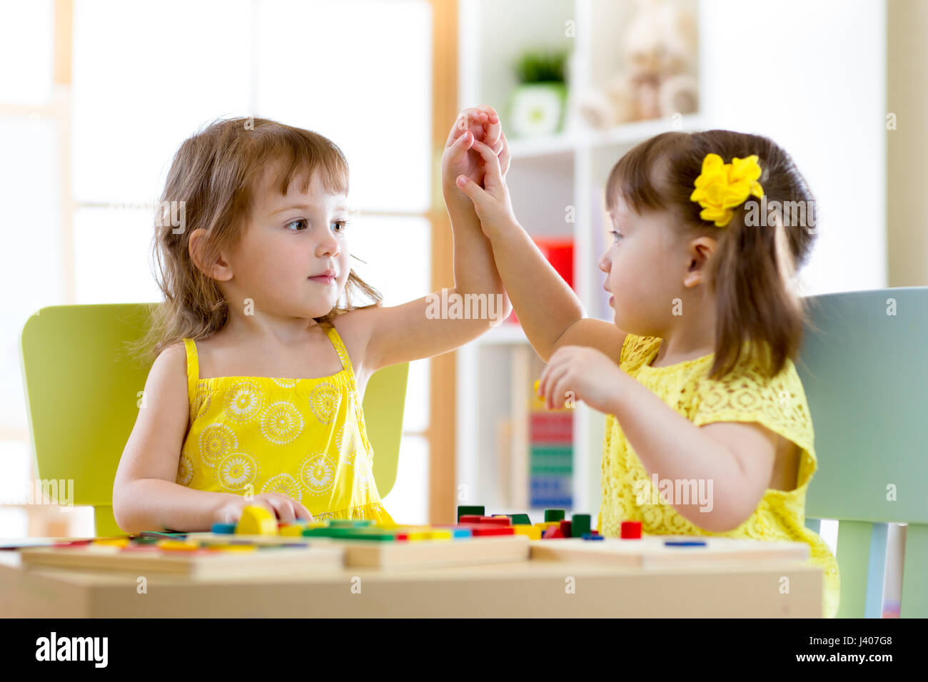 Zwei niedliche kleine Mädchen spielen zusammen in der Kindertagesstätte Stockfoto