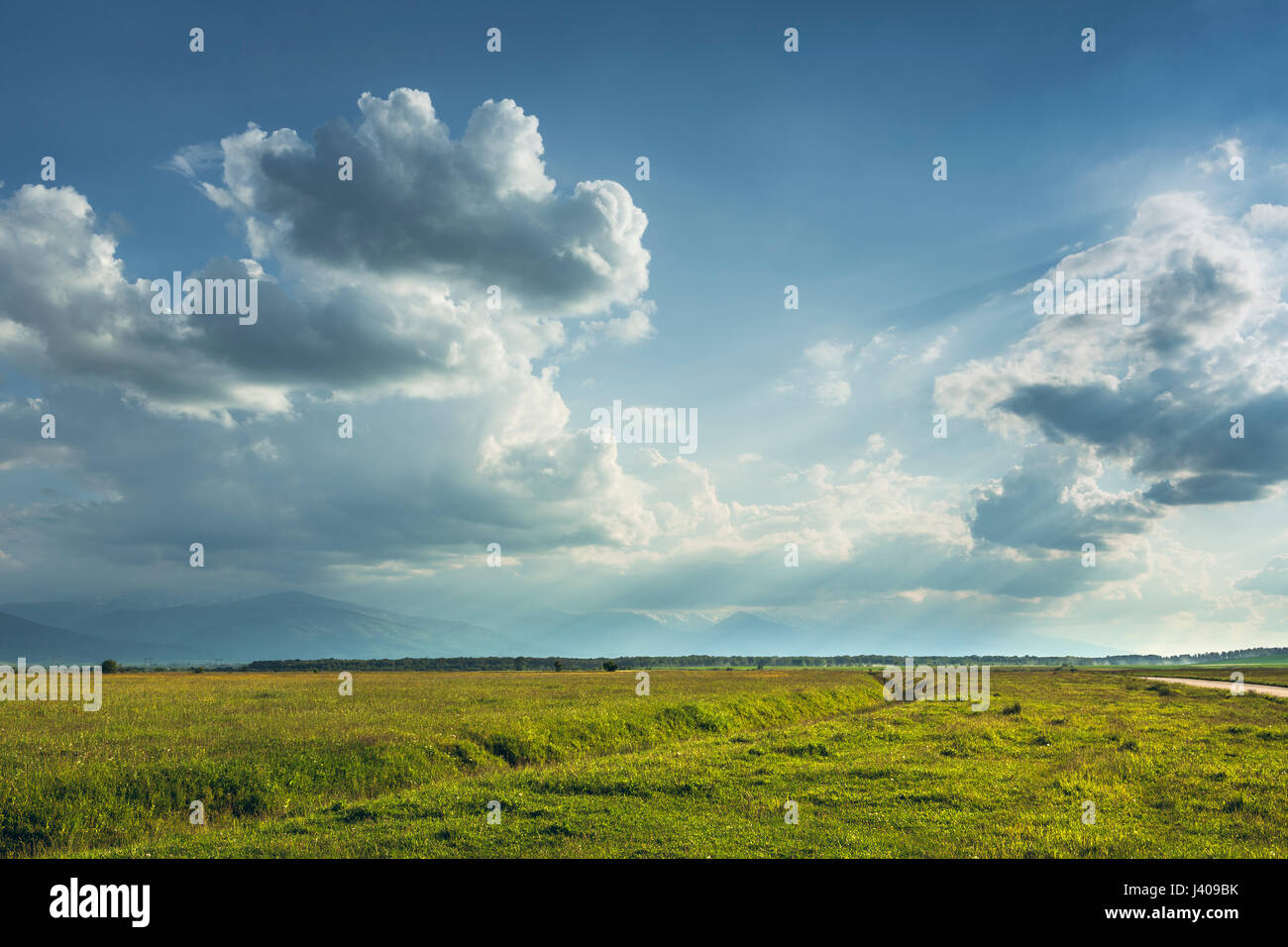 Landschaft-Landschaft mit großen grünen Weiden und Sonnenstrahlen, die durch stürmischen Wolken in Region Transsilvanien, Rumänien. Stockfoto