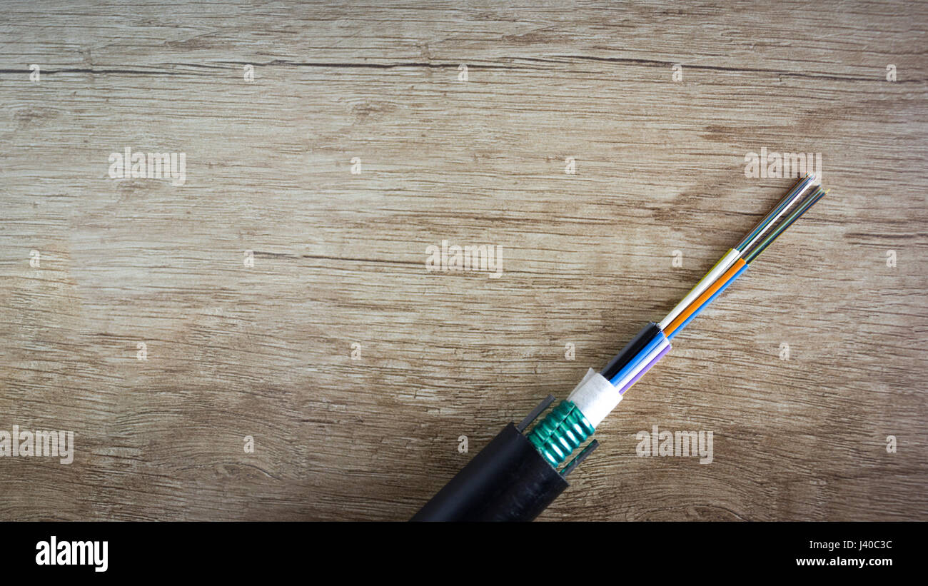 Glasfaserkabel auf Schreibtisch aus Holz. Fiber-to-home Internet - FTTH Stockfoto