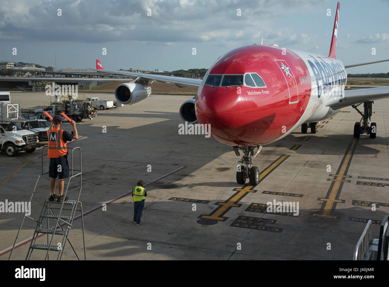 Flugzeug-Marschall mit Signalisierung-Sticks, um einen großen Passagier-Jet, eine exakte Position auf dem Vorfeld des Flughafen Tampa USA zu führen. Mai 2017 Stockfoto