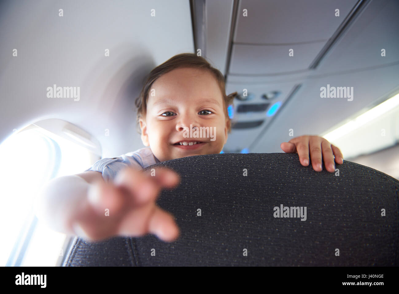 Kleine Junge Reisen in Airlane lächelnd. Untergeordnete Ebene Fluggast Stockfoto