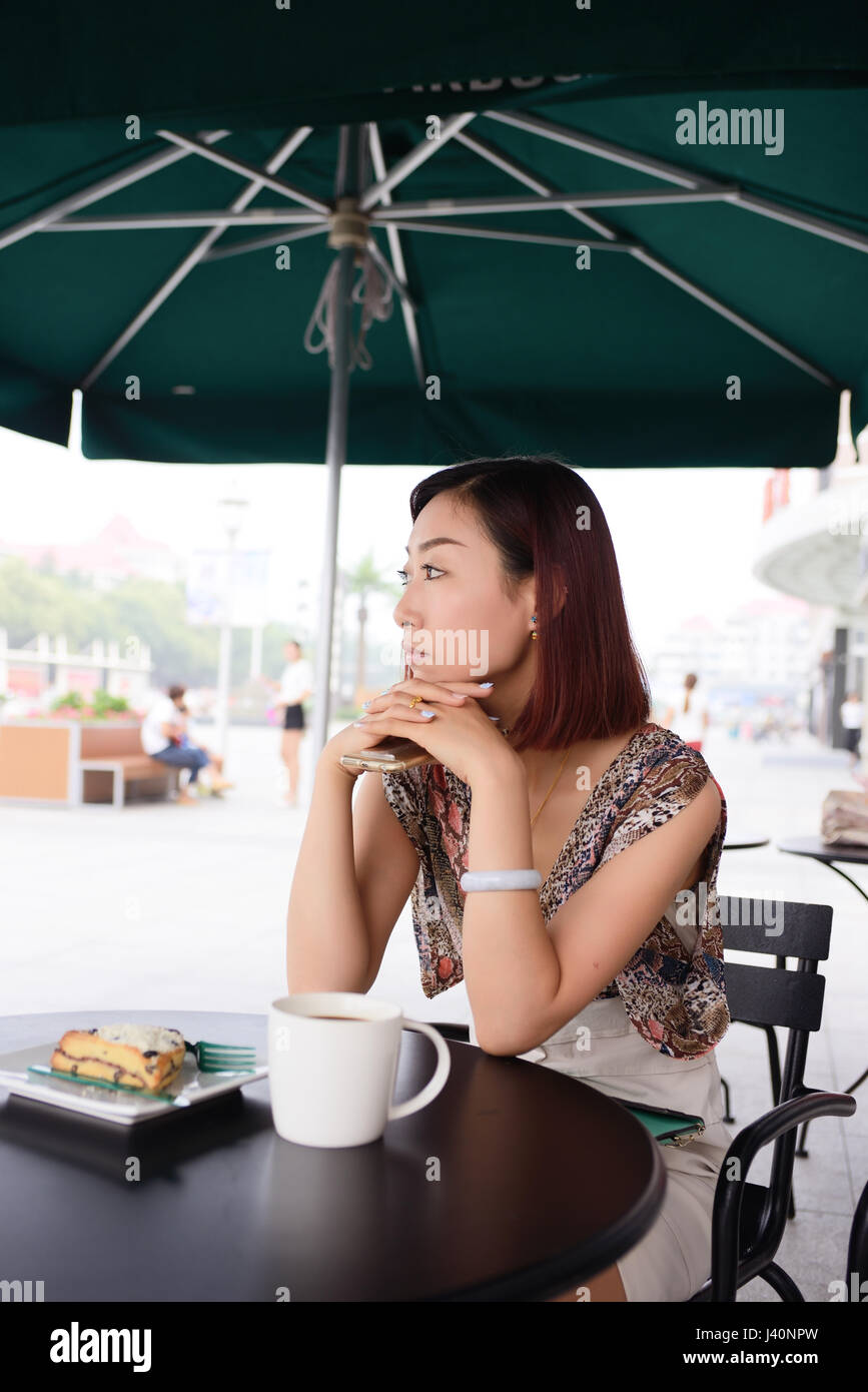 Schöne Frau verwenden ein Mobiltelefon in ein Cafe Stockfoto