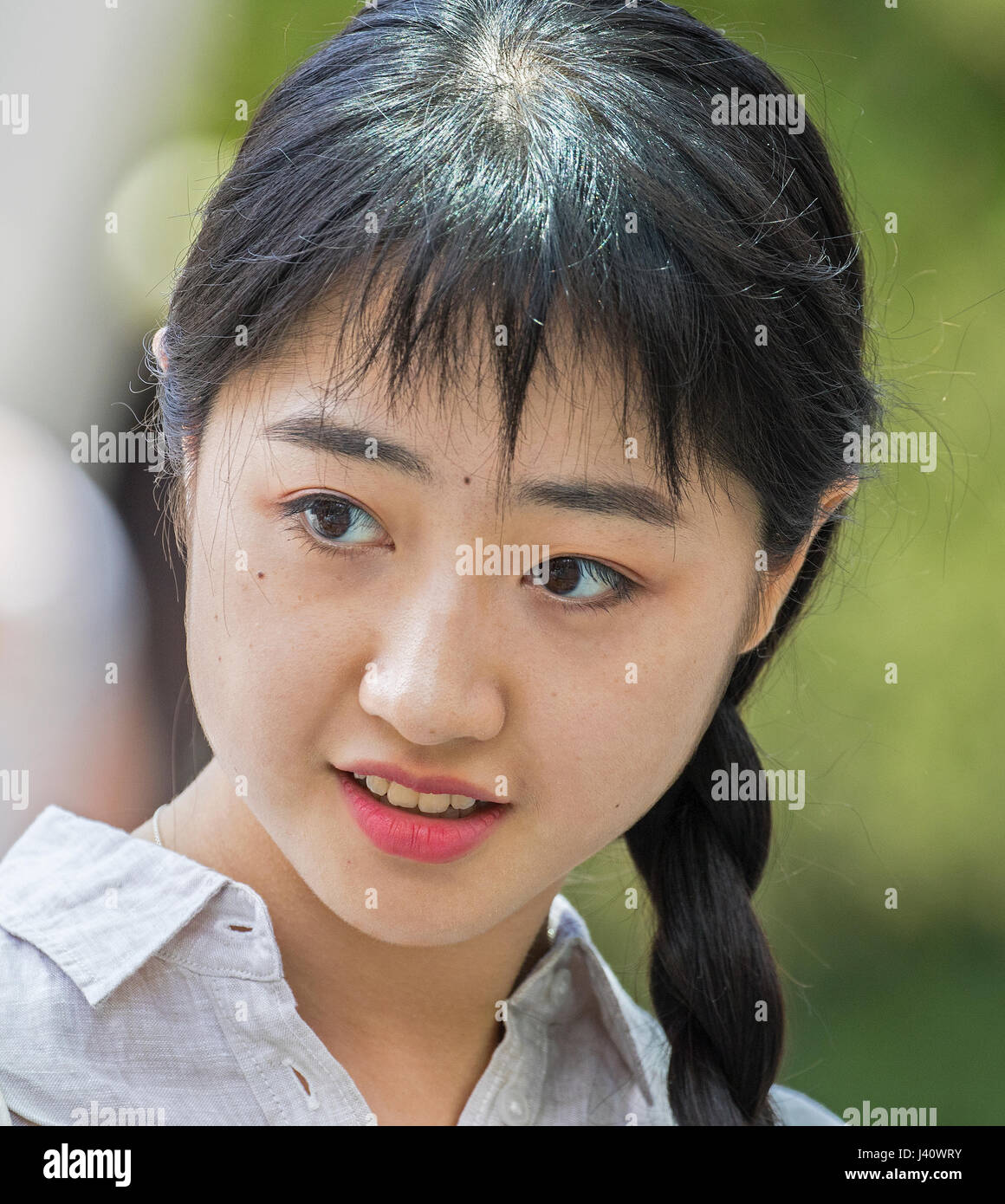 hübsche Frau/Asiatin mit langen schwarzen Zöpfen Stockfoto