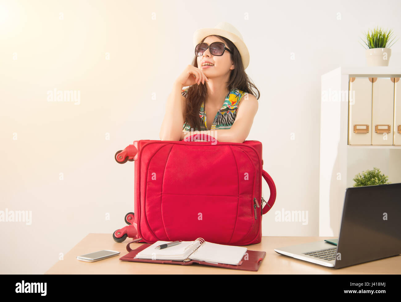 Fröhliche Büroangestellte mit Gepäck und Sonnenbrillen für langen Urlaub bereit. Gemischte Rassen asiatische chinesische Modell. Stockfoto
