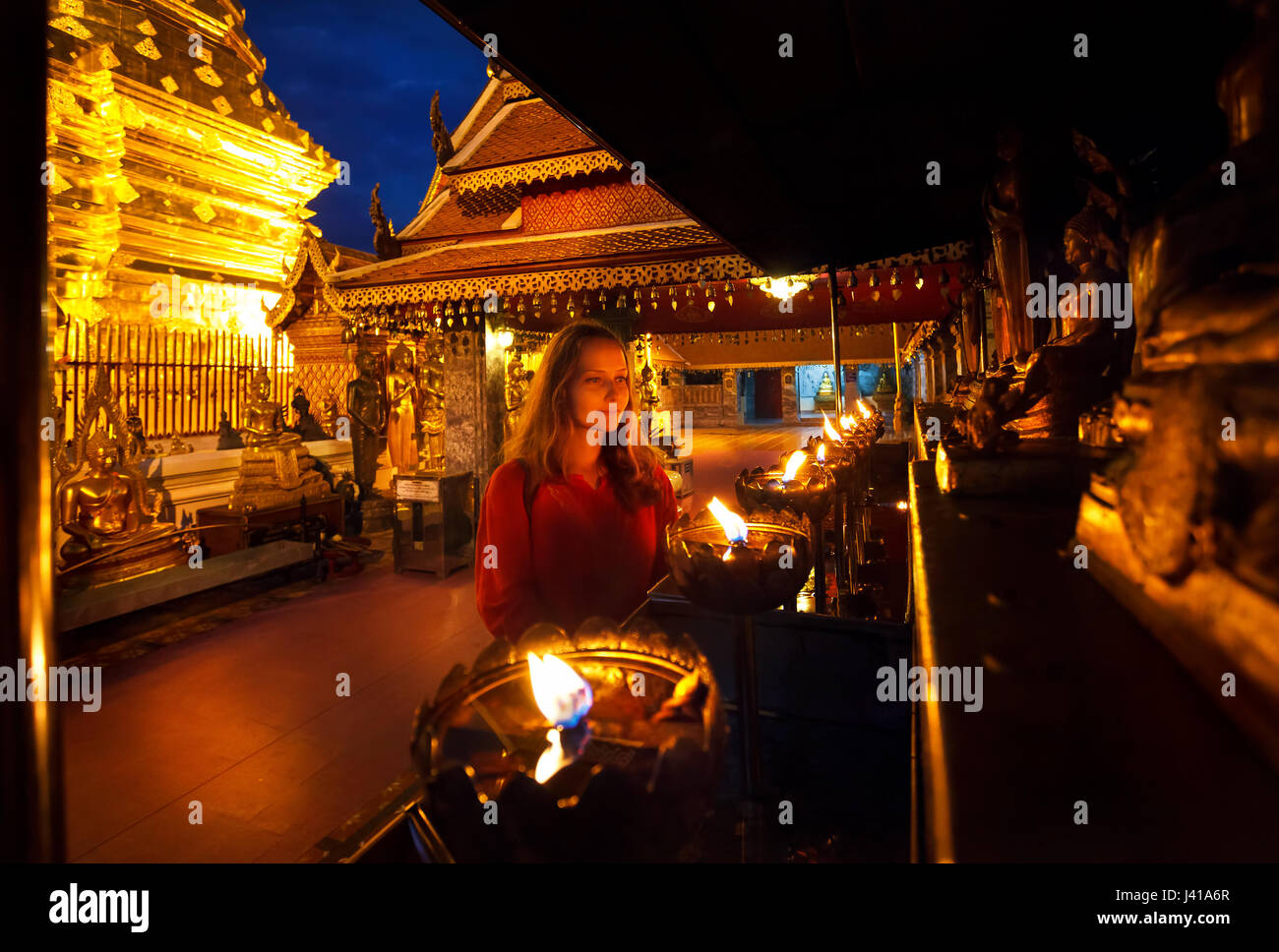 Frau touristischen Blick auf Gebet Kerze leuchtet bei buddhistischen Tempel Doi Suthep nachts in Chiang Mai, Thailand Stockfoto