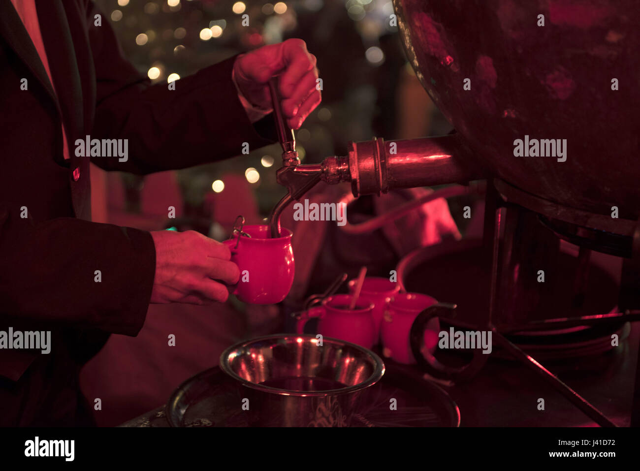 Barkeeper gießt Schnaps punch von einem Dampfkessel auf dem Weihnachtsmarkt, Berlin, Deutschland 2015 Stockfoto