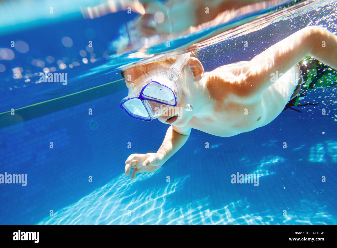 Kind schwimmt unter Wasser im Schwimmbad mit Schnorchel Maske Stockfoto