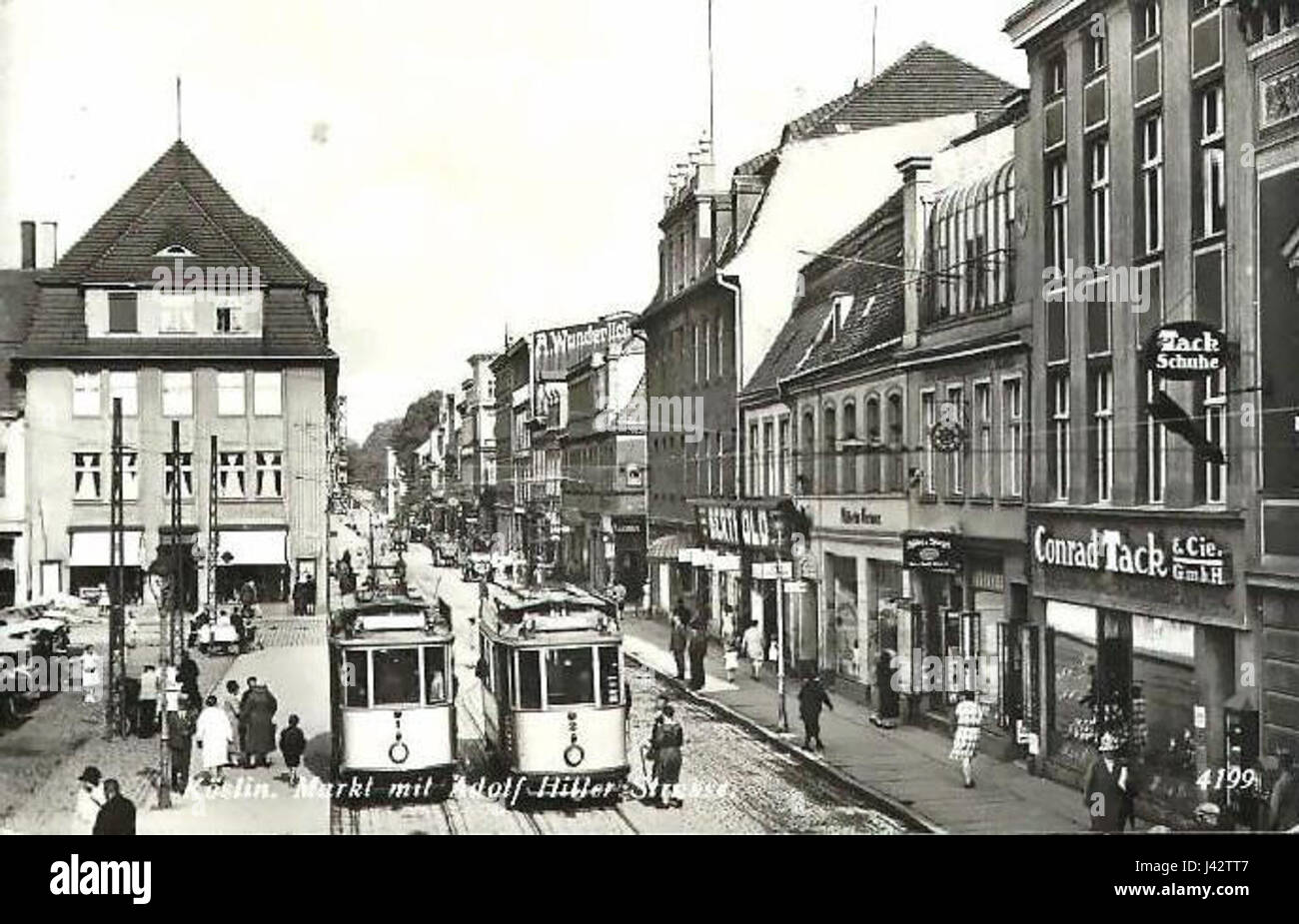 Koslin Markt, heute Teil Polens, mit Adolf Hitler Straße, einer Straße, die in Nazi-Deutschland benannt wurde. Der Titel bezieht sich auf den historischen Kontext des Gebiets während des Zweiten Weltkriegs und des NS-Regimes. Stockfoto