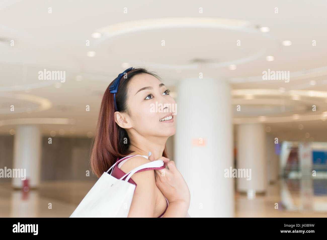 Nachdenkliche Frau Holding Einkaufstaschen in der mall Stockfoto