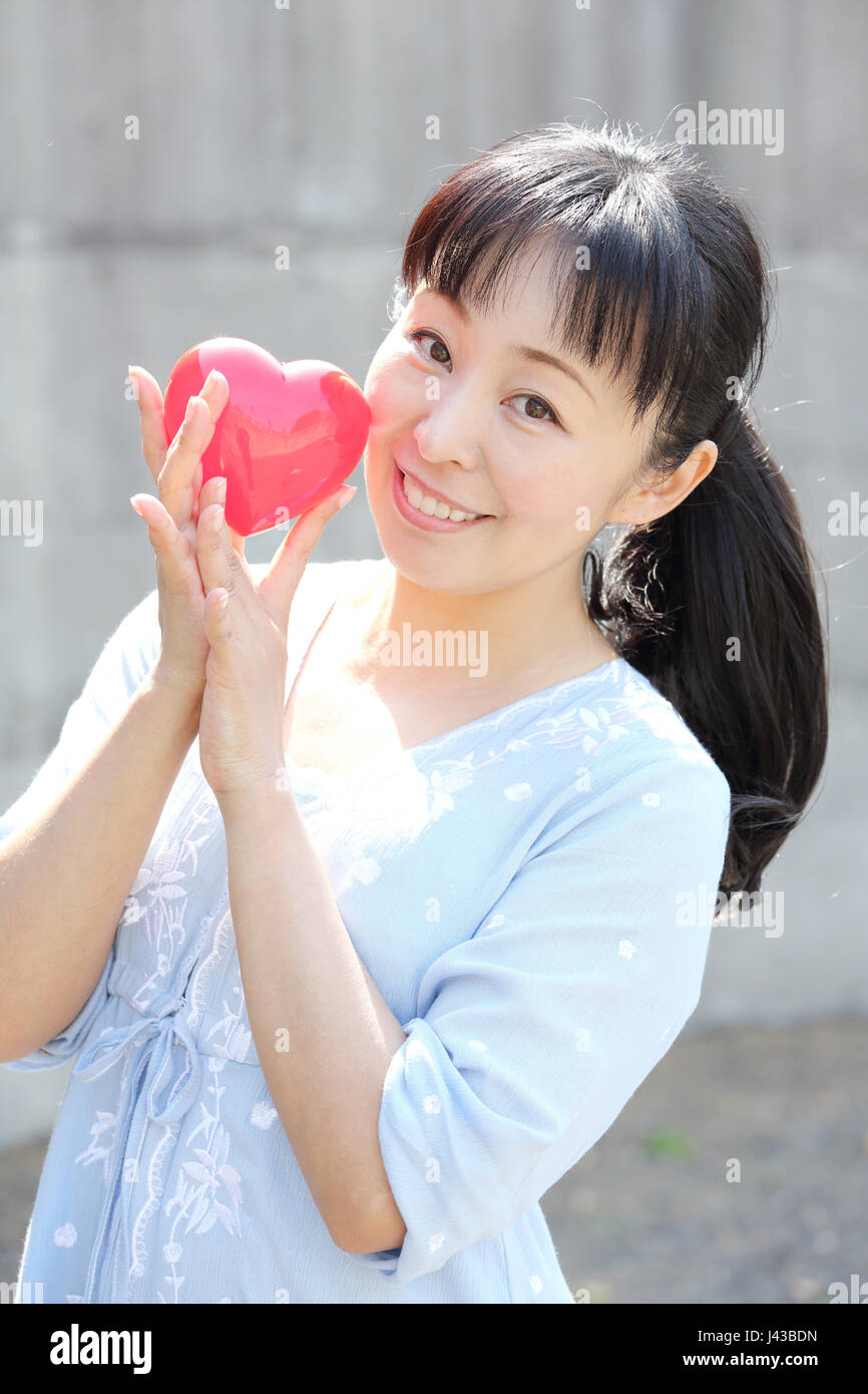 Porträt der jungen Japanerin Hand mit roten Herzen Stockfoto