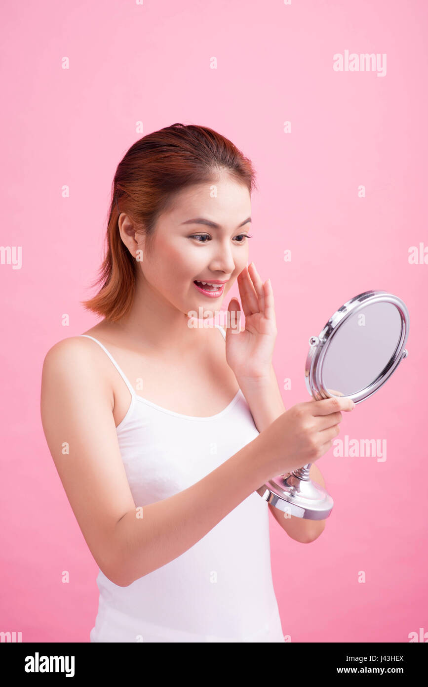 Gesicht des jungen schöne gesunde asiatische Frau und Reflexion im Spiegel Stockfoto