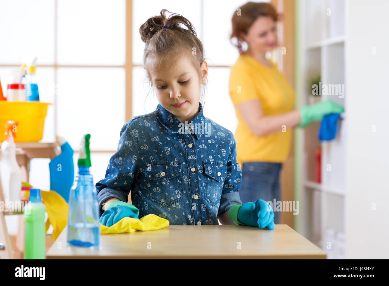Kind Mädchen und Mutter machen Reinigung im Zimmer zu Hause Stockfoto
