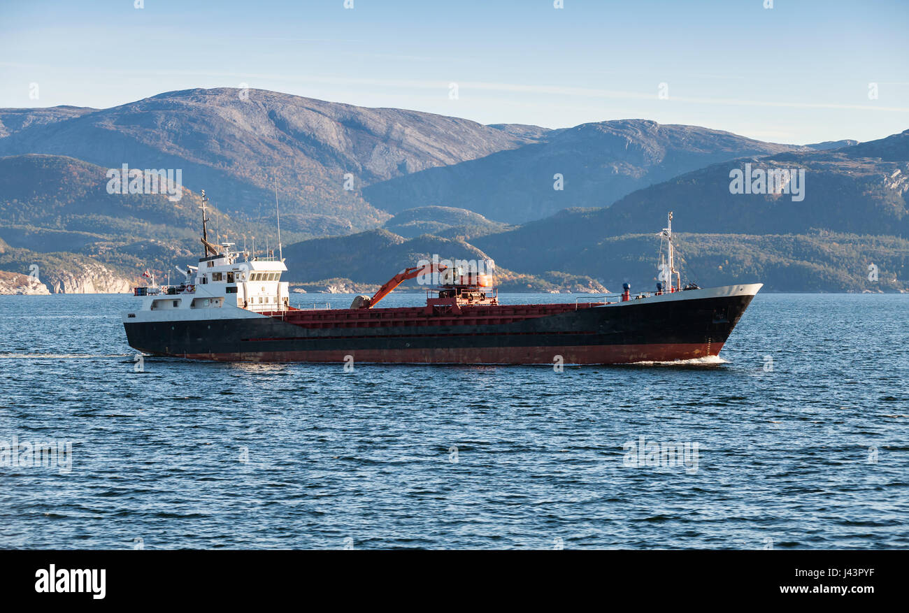 Handelsschiff mit Bagger auf Deck geht auf Nordmeer, Trondheim region Stockfoto
