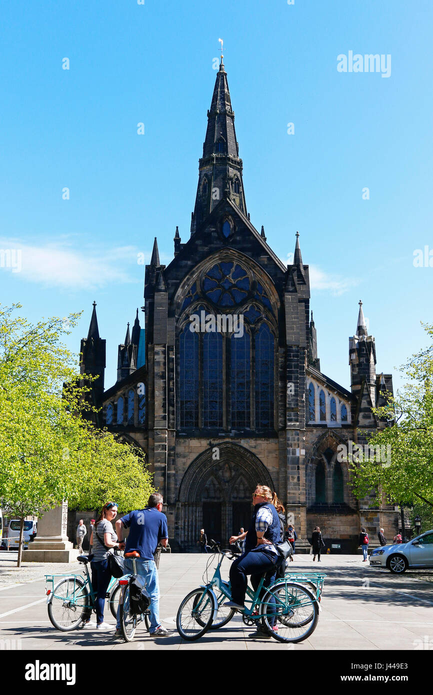 Touristen auf eine offizielle Stadt-Radtour außerhalb Glasgow Cathedral in Cathedral Square und gegeben ein Informationsgespräch durch den Guide zu stoppen, Stockfoto