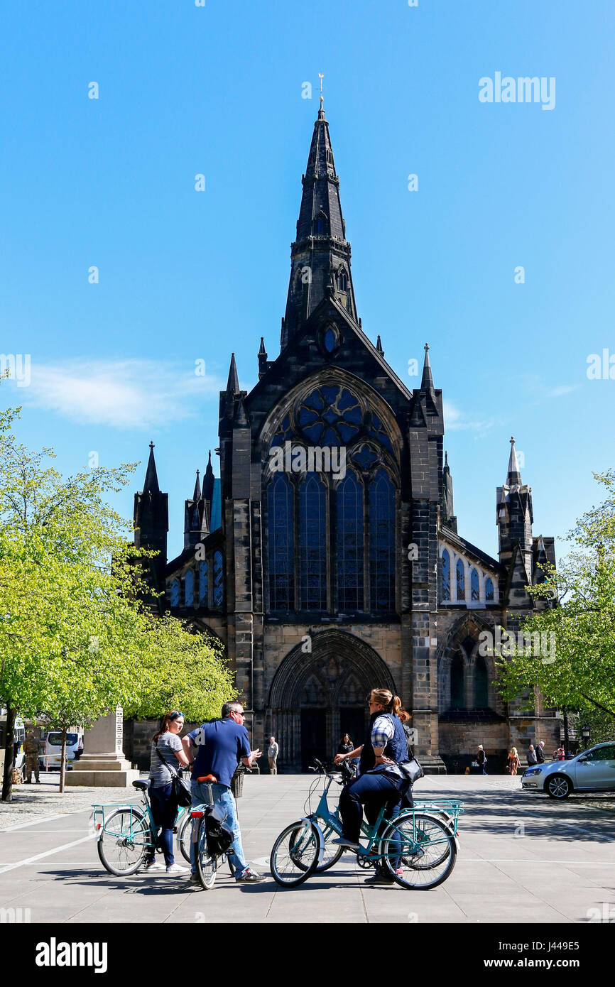 Touristen auf eine offizielle Stadt-Radtour außerhalb Glasgow Cathedral in Cathedral Square und gegeben ein Informationsgespräch durch den Guide zu stoppen, Stockfoto