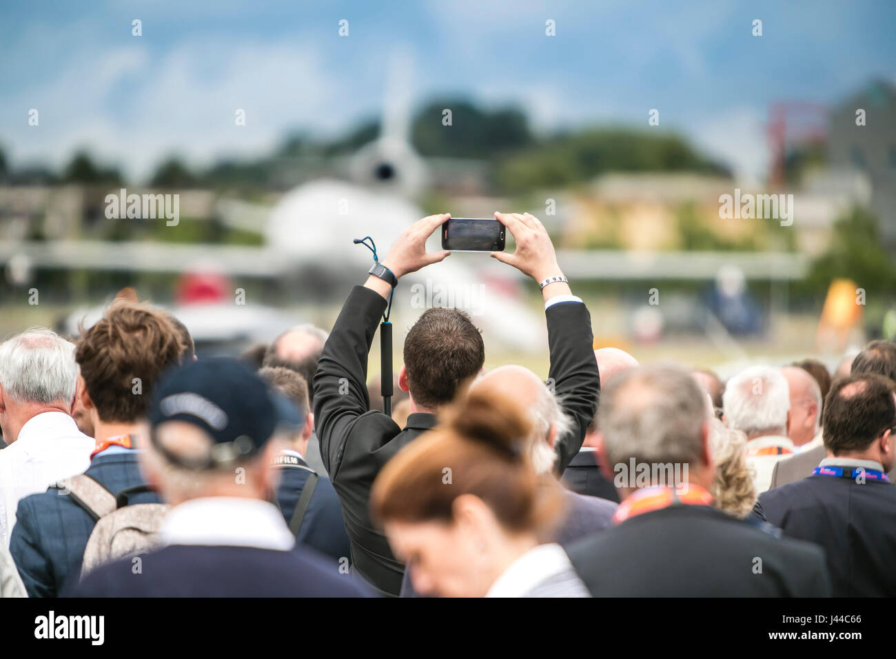 Zuschauer nehmen selfie bei Air Show mit dem Flugzeug im Hintergrund Stockfoto