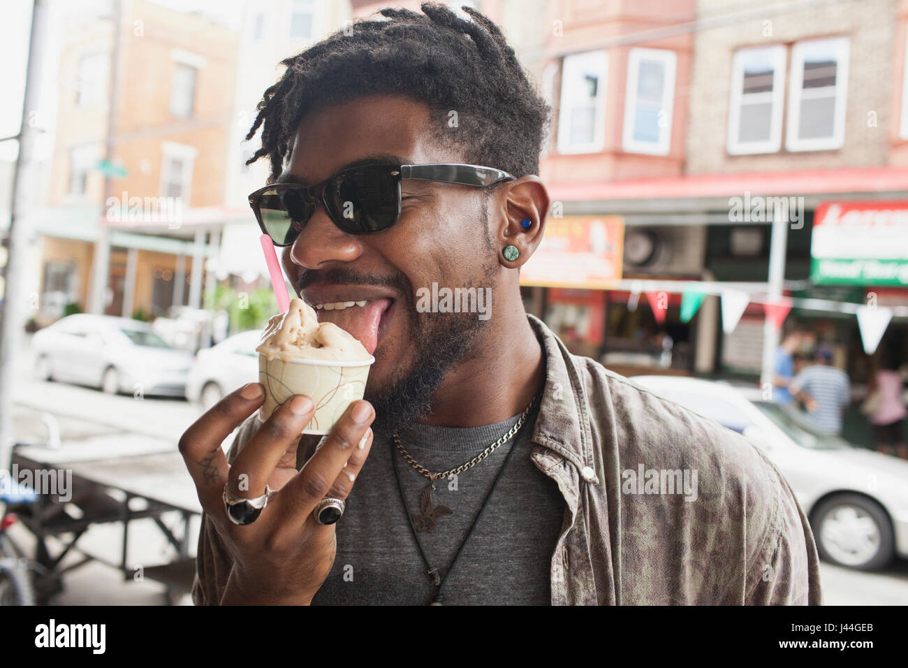 Ein junger Mann essen gefrorenen Joghurt. Stockfoto