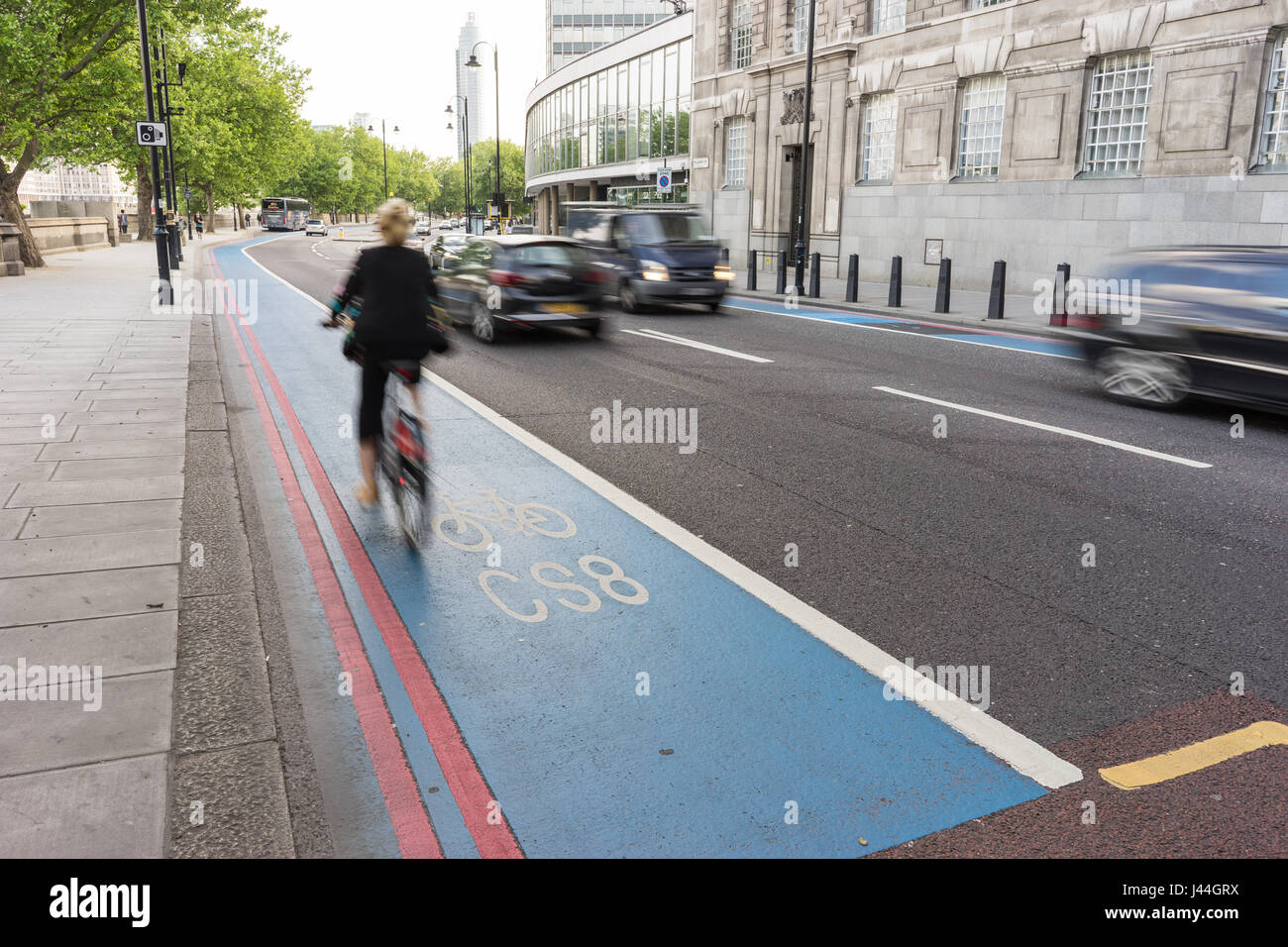 Frau pendeln mit dem Fahrrad und Radfahren entlang eines Zyklus super-Autobahn oder mit dem Fahrrad Lane in London mit rauschenden Verkehr übergeben. Stockfoto